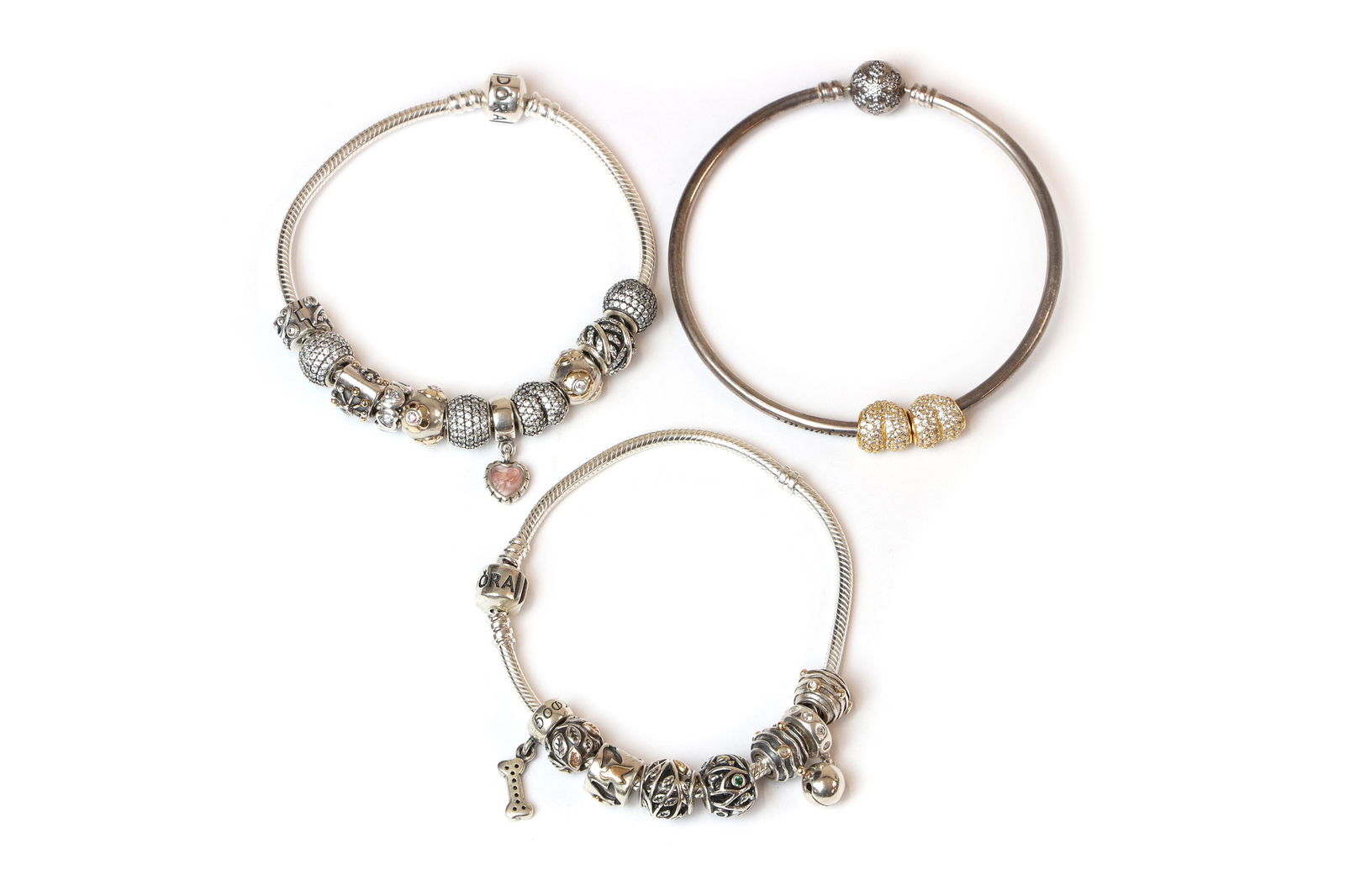 Two Pandora charm bracelets,: Two Pandora charm bracelets, Two Pandora charm bracelets, 11 charms, 212mm long, 8 charms, 212mm long, together with a Pandora engraved charm bangle, machine engraved with 'unique as you are', to two