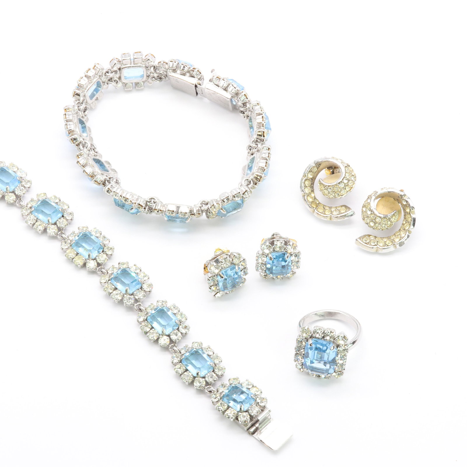 A Christian Dior faux aquamarine paste suite, c.1972,: A Christian Dior faux aquamarine paste suite, c.1972, A Christian Dior faux aquamarine paste suite, c.1972, comprising a bracelet with a series of articulated clusters of step cut faux aquamarine, to