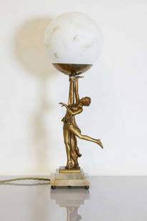 An Austrian Art Deco gilt-pewter table lamp,: An Austrian Art Deco gilt-pewter table lamp, An Austrian Art Deco gilt-pewter table lamp, c.1930, by Josef Lorenzl, modelled as a dancer holding aloft a spherical shade, raised on a stepped onyx plint