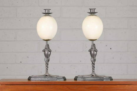 An unusual pair of Anthony Redmile candlesticks: An unusual pair of Anthony Redmile candlesticks An unusual pair of Anthony Redmile candlesticks, 1970s, each with an ostrich egg mounted with a sconce and drip pan, raised on a cast stand modelled as