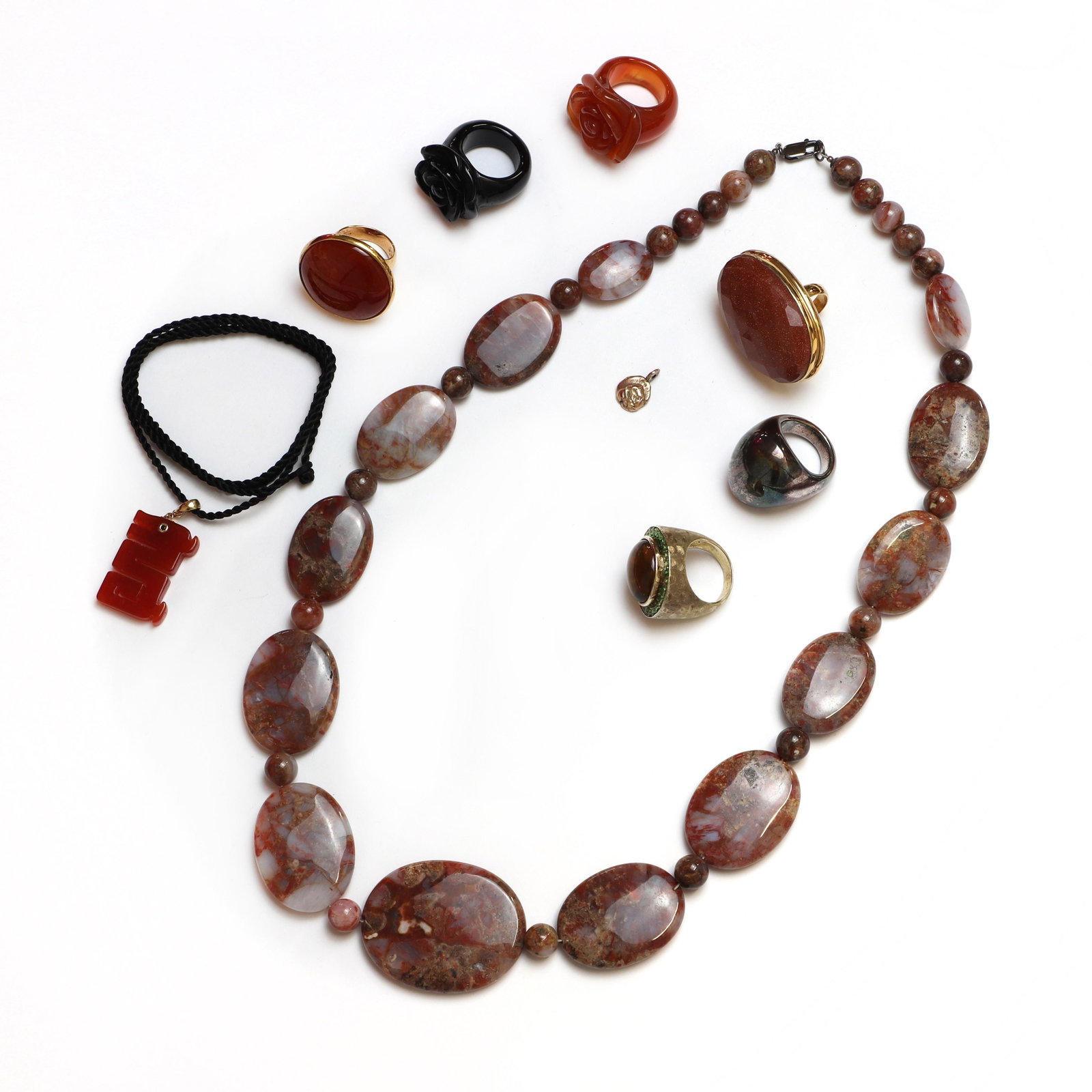 A collection of silver, gold and hardstone jewellery,: A collection of silver, gold and hardstone jewellery, A collection of silver, gold and hardstone jewellery, to include a gold carnelian dragon pendant, 22mm x 45mm, suspended on black cord, tested as 