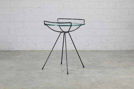 An iron and glass side table,: An iron and glass side table, An iron and glass side table, in the manner of Sol Bloom, with a circular glass top, 54.5cm diameter 62.5cm high Condition Report: Some wear to the frame of the table. Mi