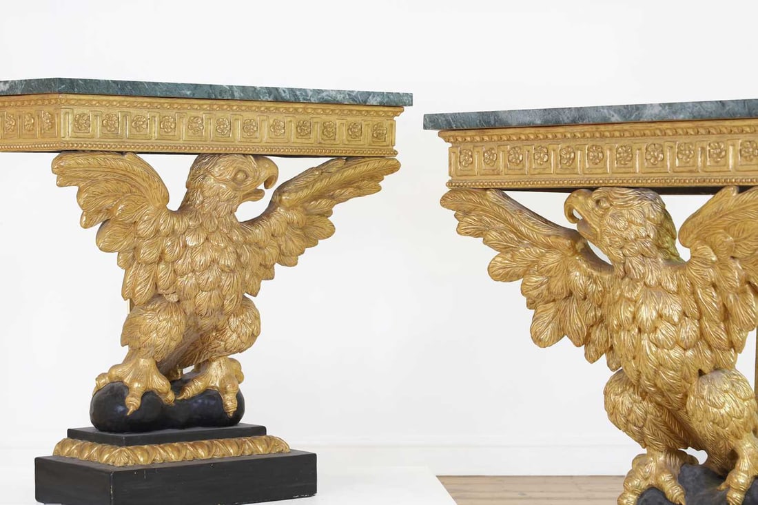 A pair of George II-style carved giltwood console tables,: A pair of George II-style carved giltwood console tables, A pair of George II-style carved giltwood console tables, 20th century, in the manner of William Kent, each with a serpentine marble top over