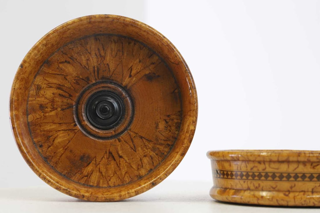 A pair of burr fruitwood coasters,: A pair of burr fruitwood coasters, A pair of burr fruitwood coasters, 19th century, each of circular form with a moulded roundel to the centre, the shallow rim with parquetry banding, 11cm diameter 3c