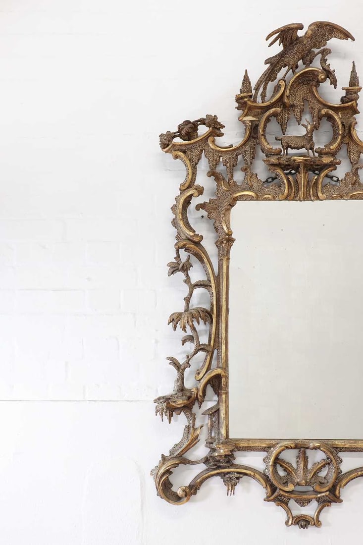 A carved giltwood pier glass in the manner of Thomas Johnson,: A carved giltwood pier glass in the manner of Thomas Johnson, A carved giltwood pier glass in the manner of Thomas Johnson, 19th century, the elaborate rococo frame surmounted with ho-o birds and a ki