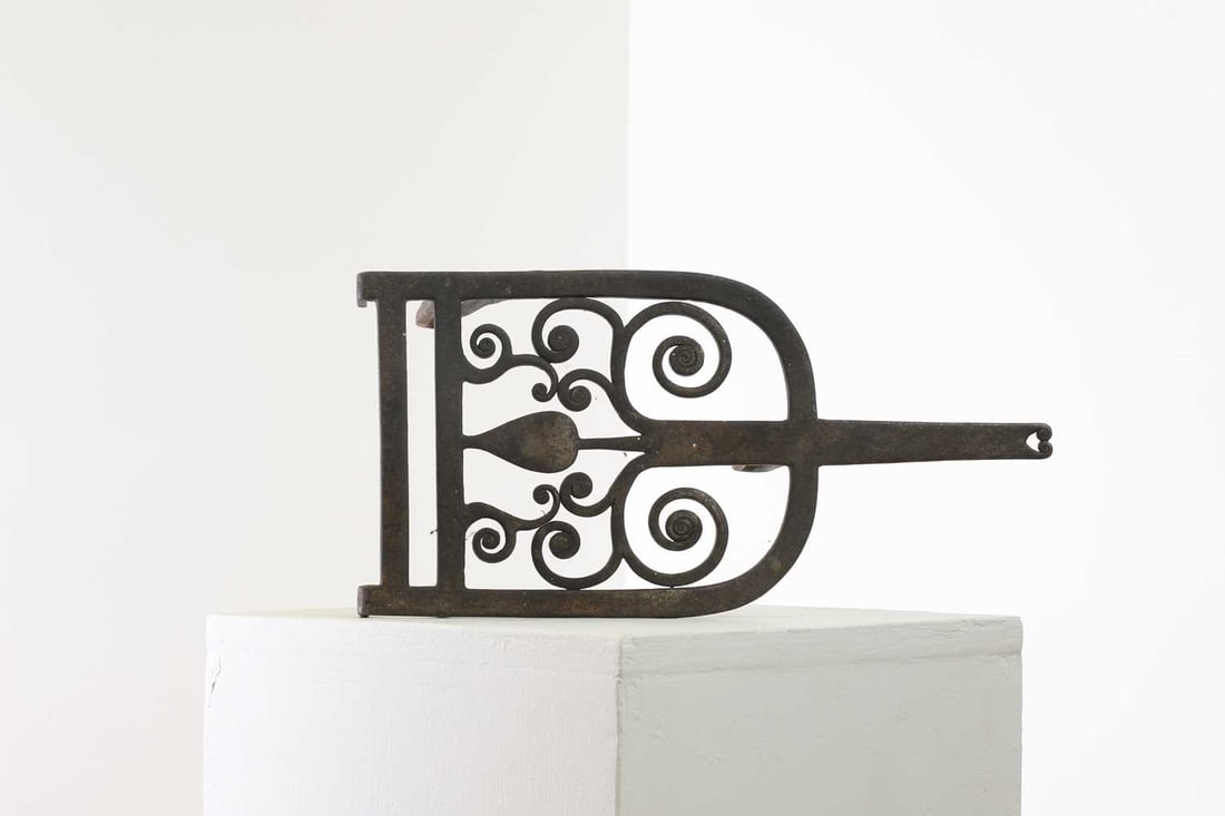 An Arts and Crafts iron trivet by Edward Spencer,: An Arts and Crafts iron trivet by Edward Spencer, An Arts and Crafts iron trivet by Edward Spencer, late 19th century, with pierced scrolling foliate decoration, 37cm wide 18cm long 14cm high Provenan