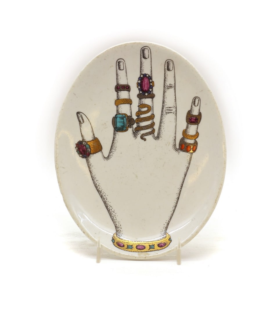 A Fornasetti porcelain 'Mano' dish: A Fornasetti porcelain 'Mano' dish A Fornasetti porcelain 'Mano' dish, of oval form, printed mark, 16.5cm long Condition Report: Chip to the edge. Scratches and wear throughout.