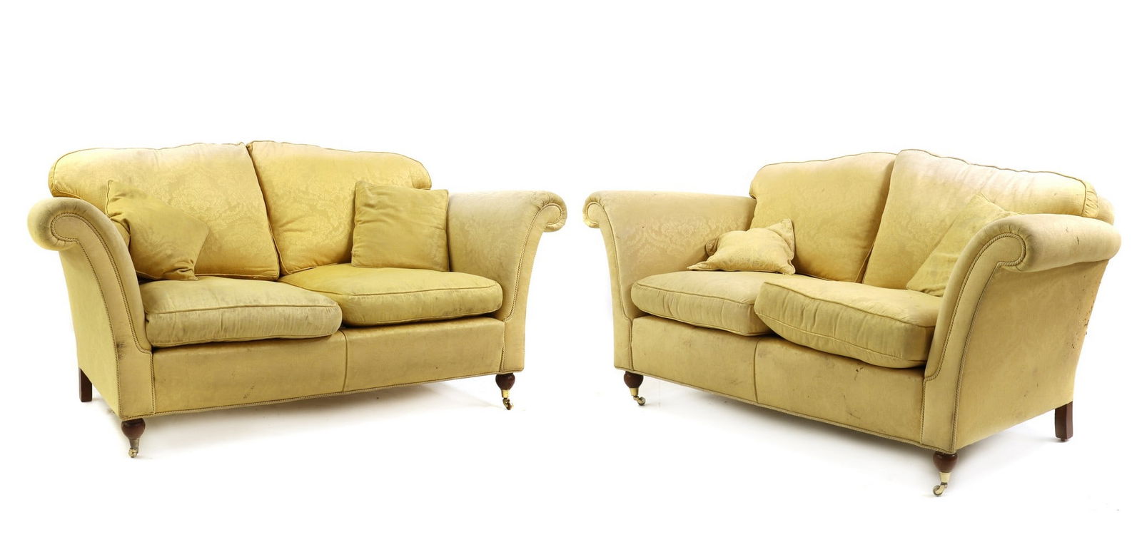 A pair of upholstered settees: A pair of upholstered settees A pair of upholstered settees, 20th century, each upholstered in lemon damask, raised on front turned supports terminating in castors, 195cm wide 100cm deep 90cm high, se