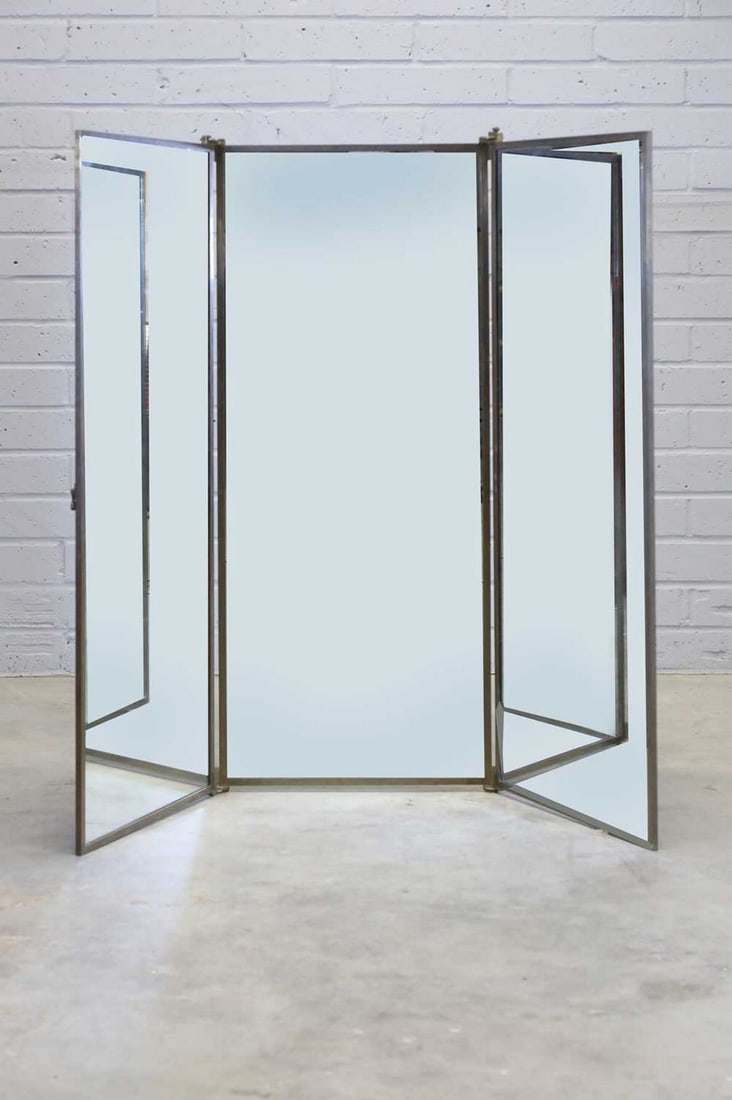 A French Art Deco brass hanging triptych mirror,: A French Art Deco brass hanging triptych mirror, A French Art Deco brass hanging triptych mirror, 1930s, by Miroir Brot, with three hinged mirror plates, the reverse with red panels, each panel 53cm w