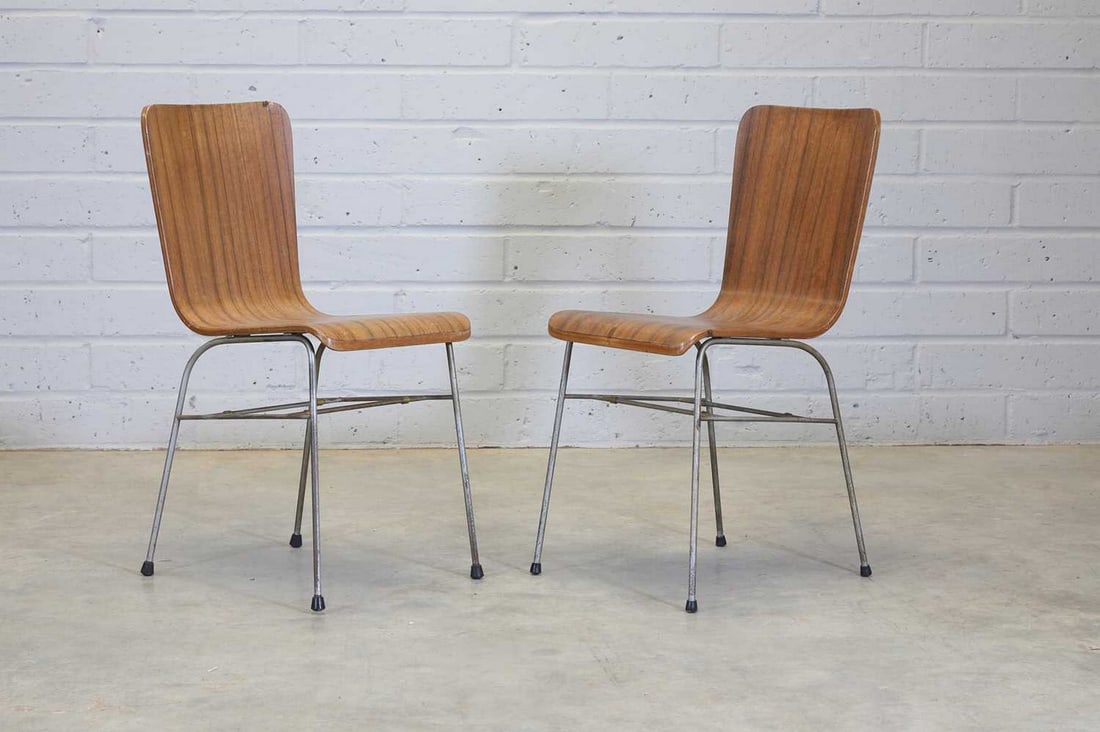 A pair of 'Toby' stacking chairs,: A pair of 'Toby' stacking chairs, A pair of 'Toby' stacking chairs, designed in 1956 by Neil Morris for Morris of Glasgow, each with a walnut-veneered bent-ply seat, raised on tubular steel supports,