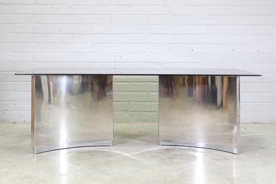 An ROR International dining table,: An ROR International dining table, An ROR International dining table, 1974, designed by Ringo Starr and Robin Cruikshank, with a rectangular glass top, raised on two brushed steel supports, each of tr