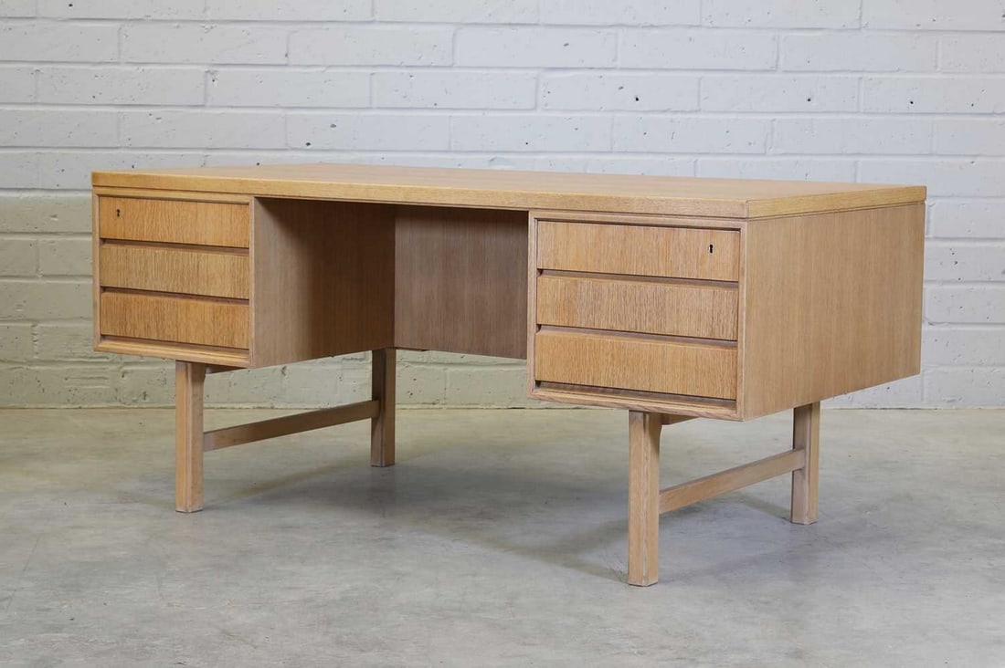 A Danish 'Model 76' oak desk,: A Danish 'Model 76' oak desk, A Danish 'Model 76' oak desk, c.1965, designed by Gunni Omann for Omann Jun, the rectangular top raised on two banks of graduated drawers with shelves to the fronts, each