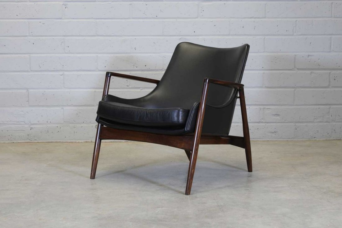 A Danish stained beech armchair,: A Danish stained beech armchair,attributed to Ib Koford Larsen for Selig, upholstered in black leather, raised on tapering supports, with manufacturer's badge to the frame,79cm wide77cm deep72cm high,