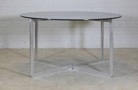 A glass and steel table,: A glass and steel table, A glass and steel table, 1970s, designed by Michel Boyer, with a circular smoked glass top, raised on a four-legged folding stand, 128cm diameter 71.5cm high Condition Report: