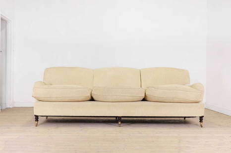 A three-seater sofa by George Smith,: A three-seater sofa by George Smith, A three-seater sofa by George Smith, of recent manufacture, upholstered in yellow fabric and raised on ring-turned supports, terminating in brass caps and castors,