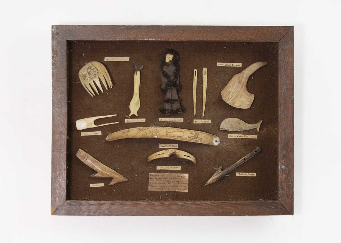 An oak-framed display of marine ivory, bone and antler 'tools and curios',: An oak-framed display of marine ivory, bone and antler 'tools and curios', An oak-framed display of marine ivory, bone and antler 'tools and curios', 20th century, comprising ten mounted models with d