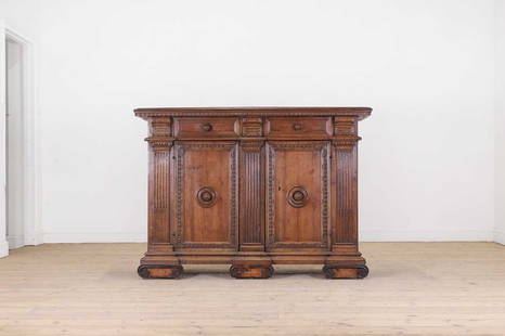 A walnut credenza,: A walnut credenza, A walnut credenza, 17th century, North Italian, Tuscany, the rectangular top above two frieze drawers and a pair of cupboard doors punctuated by stop-fluted pilasters, raised on