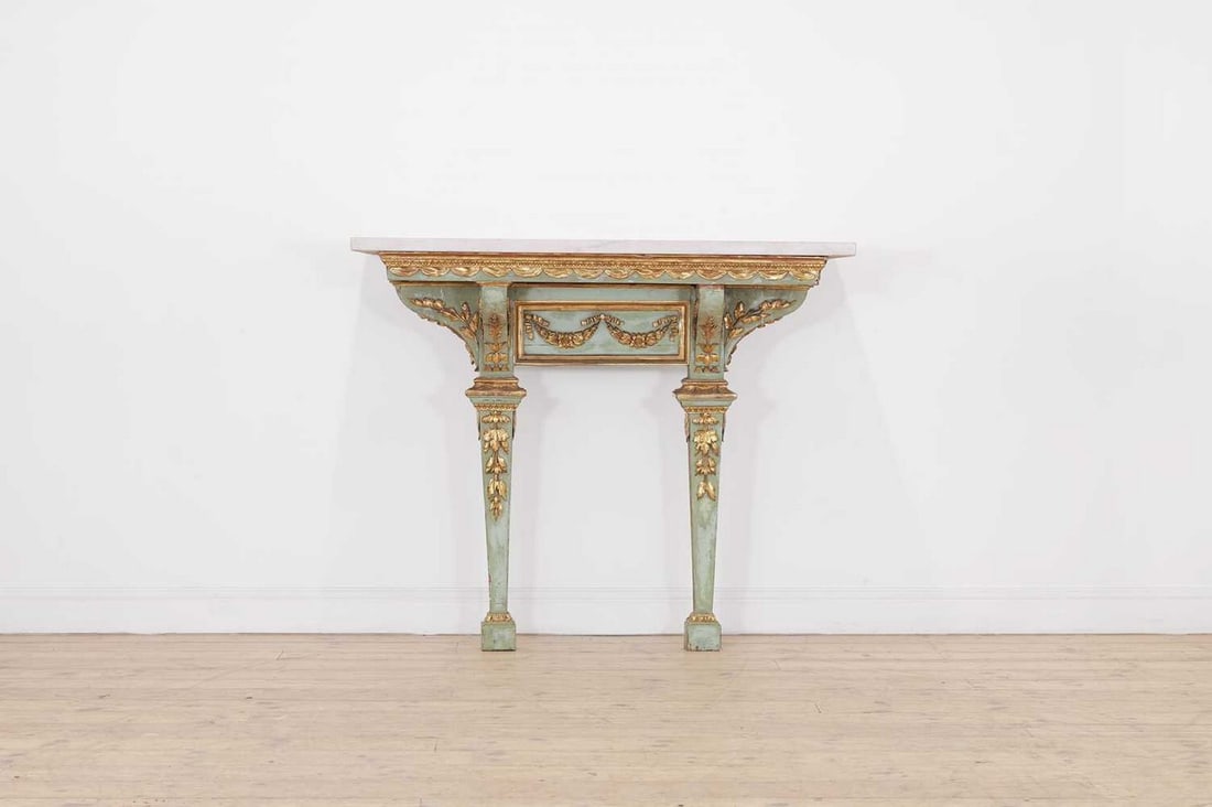 A painted and parcel-gilt pier table,: A painted and parcel-gilt pier table, A painted and parcel-gilt pier table, 20th century, the grey-veined white marble top, over carved and applied foliate and swag mounts, raised on fluted, square le