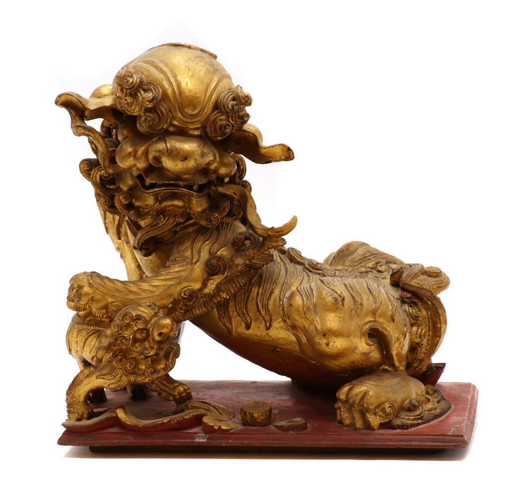 A Chinese gilt wood carving,: A Chinese gilt wood carving, A Chinese gilt wood carving, c.1900, of a Buddhist lion playing with a pup, 28.5cm long Condition Report: Cracks, chips, losses and restoration in various locations. A sma