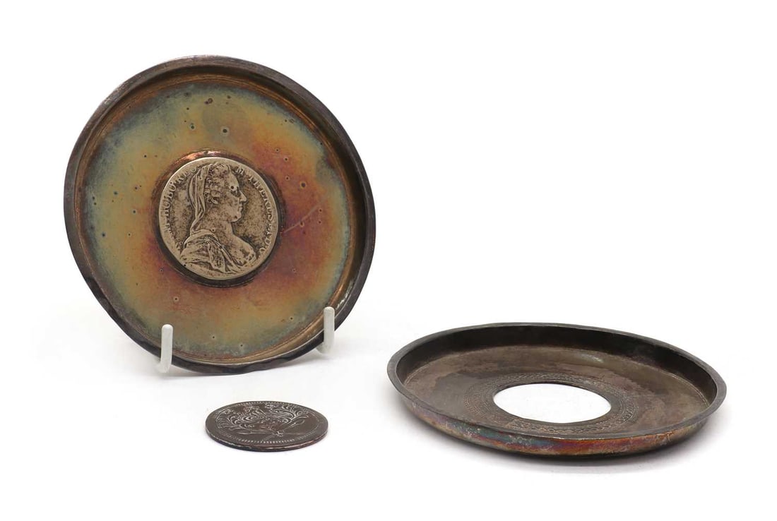 A silver coin dish,: A silver coin dish, inset with a Maria Theresa Thaler, 10cm diameter together with another silver coin dish, inset with a copper Islamic coin, 10cm diameter total 3.5ozt (2)