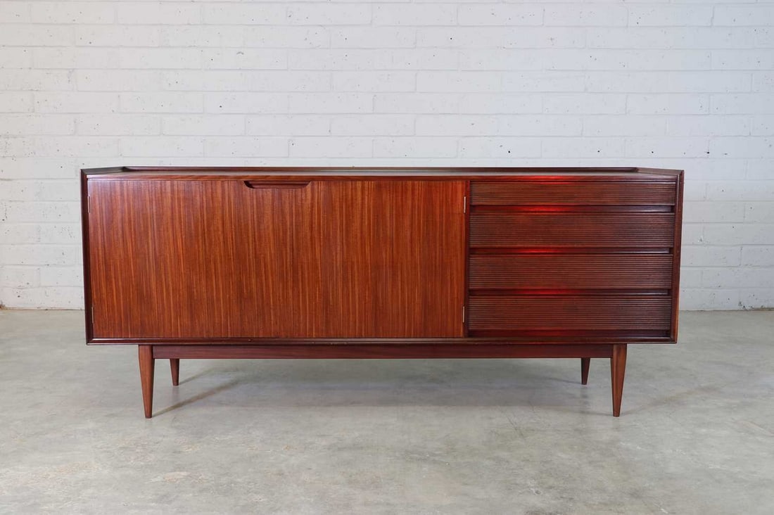 A teak and afrormosia sideboard,: A teak and afrormosia sideboard, 1960s, designed by Richard Hornby for Fyne Ladye, to the front with a pair of doors, each with recessed handles, opening on to a shelved interior, to the right with a
