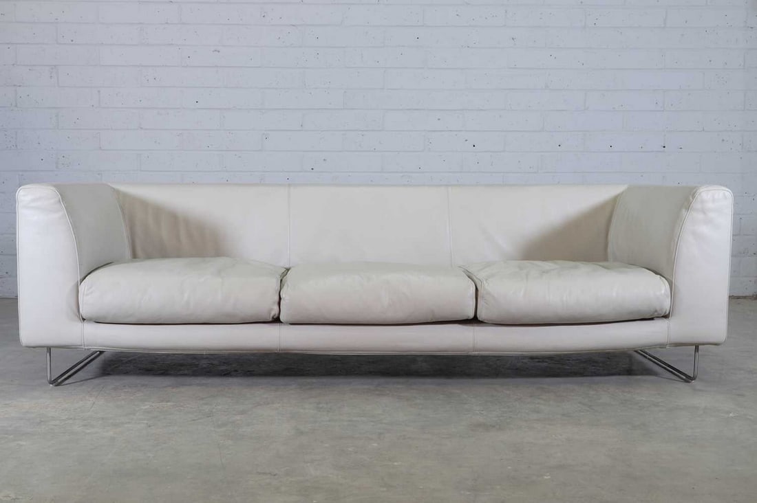 An 'Elan' sofa,: An 'Elan' sofa, designed in 1999 by Jasper Morrison for Cappellini, upholstered throughout in grey leather, with three loose seat cushions, raised on tubular steel supports, 266cm wide 82cm deep 69cm