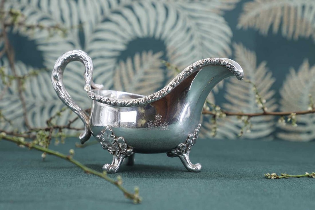 A Victorian silver sauce boat,: A Victorian silver sauce boat, by James Barclay Hennell, London 1881, with a naturalistically cast handle and raised on three acorn and oak leaf cast feet, 20cm wide 11.5cm high, 17ozt (2)