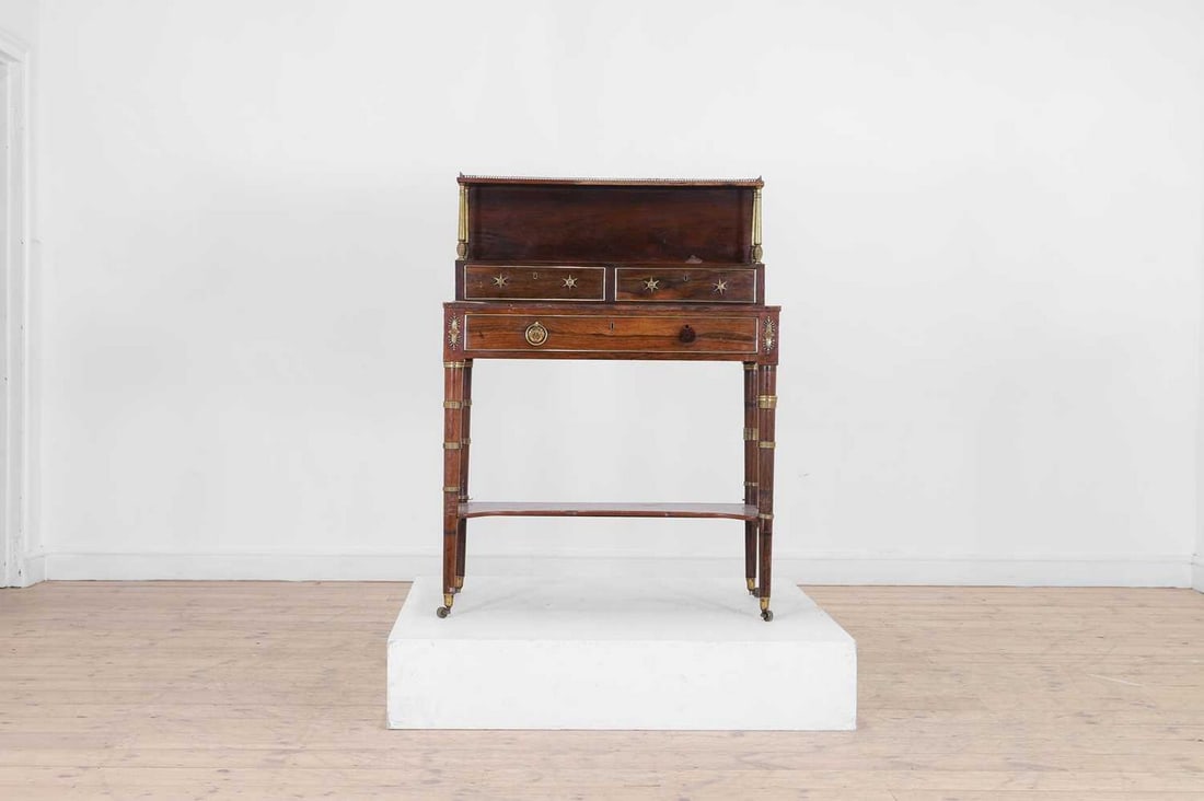 A Regency rosewood bonheur-du-jour, attributed to John McLean,: A Regency rosewood bonheur-du-jour, attributed to John McLean, c.1810, with all-over ormolu mounts, the superstructure set with a pierced gallery and column supports, above a pair of short drawers wit