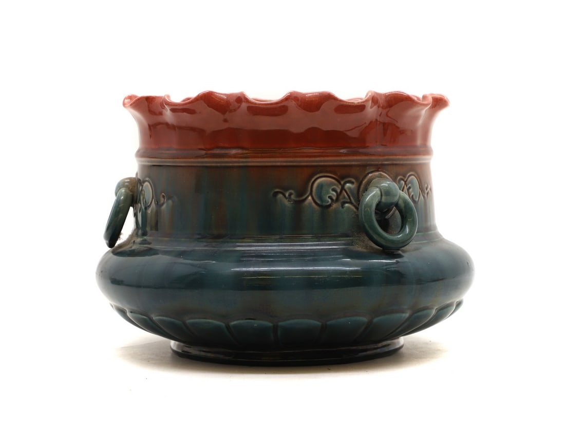 A Watcombe stoneware jardiniere,: A Watcombe stoneware jardiniere, late 19th century, in the manner of Christopher Dresser, with ringlet handles to the sides, in a red and blue high fired glaze, impressed to the underneath 'Watcombe',