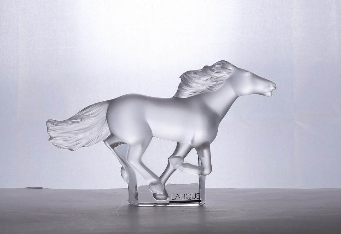A Lalique glass 'Kazak' horse: A Lalique glass 'Kazak' horse of recent manufacture, modelled in a galloping position, engraved signature, 18cm long Condition Report: Overall good order. No chips or cracks.