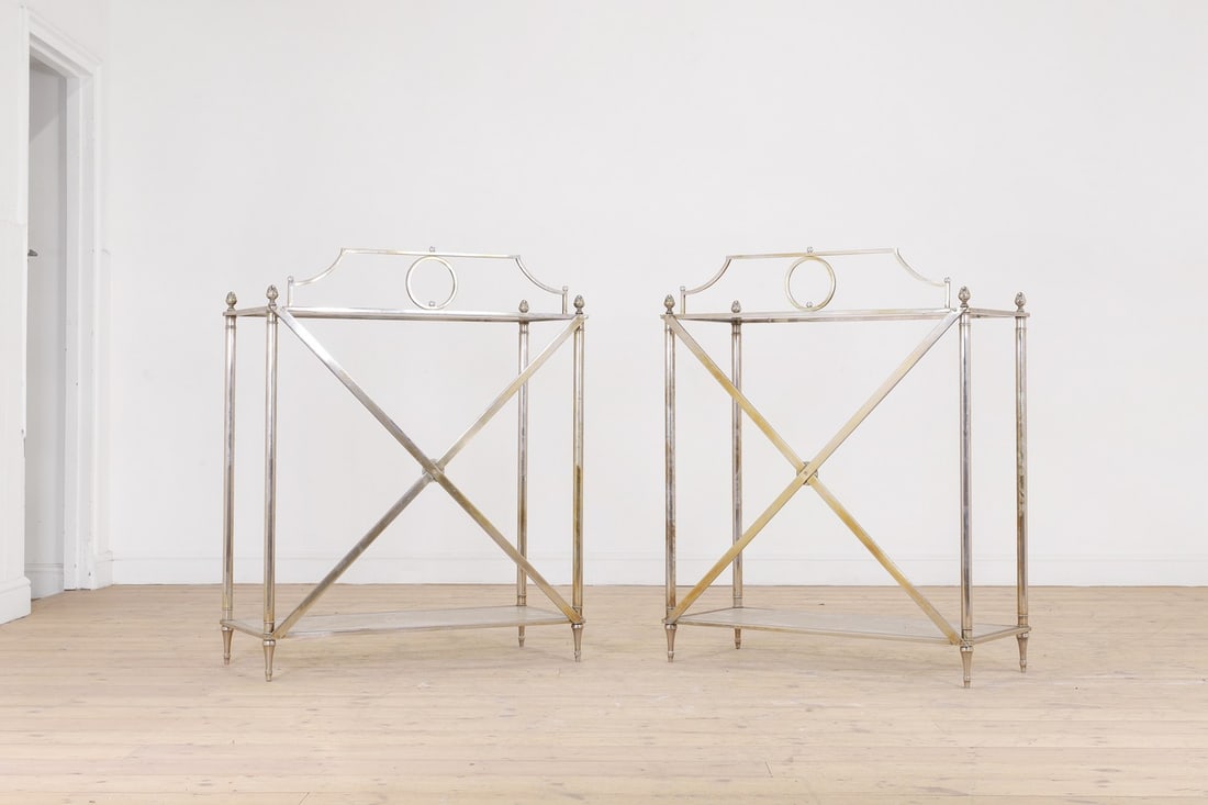A pair of modernist metal and glass console tables,: A pair of modernist metal and glass console tables, of recent manufacture, each with a rectangular glass inset top, over four column supports surmounted by acorn finials, raised on toupie feet united