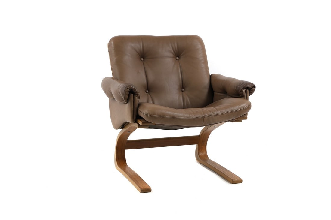 A Norwegian 'Kengu' teak lounge chair,: A Norwegian 'Kengu' teak lounge chair, 1970s, designed by Elsa and Nordahl Solheim for Rybo Rykken, the seat, back, and armrests upholstered in chocolate leather, on a cantilever teak base, 79cm wide