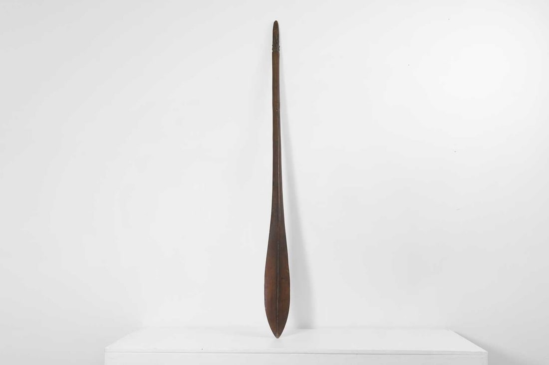 A hardwood paddle 'apa'apai' club,: A hardwood paddle 'apa'apai' club, Polynesian, of flattened spatulate form with a medial ridge, the terminal carved with figures, 10cm wide 3.5cm deep 128.5cm long Condition Report: Small section of r