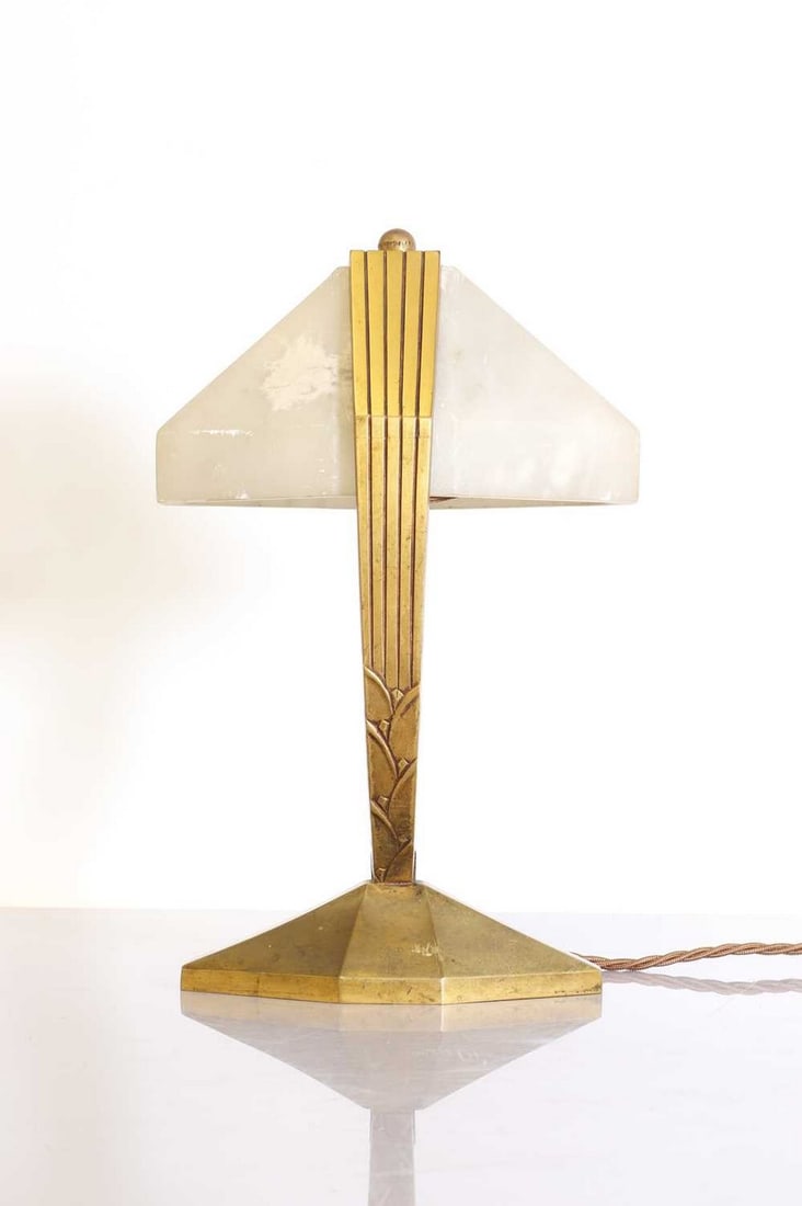 An Art Deco table lamp,: An Art Deco table lamp, mounted with an alabaster shade, with patinated gold mounts, and a switch to the side, 18.5cm wide 13.5cm deep 30cm high Condition Report: Not operational when tested - with a