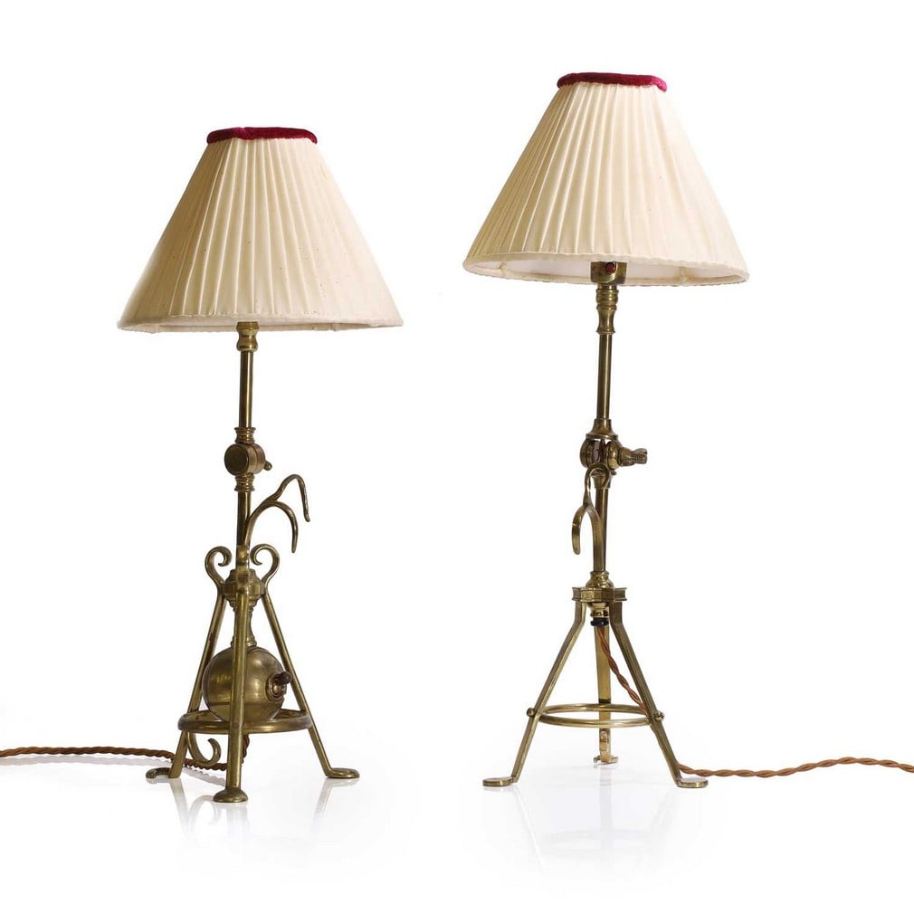 Attributed to WAS Benson (1854-1924),: Attributed to WAS Benson (1854-1924), a near pair of brass Pullman lamps, early 20th century, each of tripod brass construction, one example with a spherical toggle house to the bottom, each with a pl