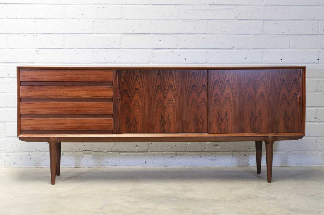 Gunni Omann (Danish, 1930-2009),: Gunni Omann (Danish, 1930-2009), a Danish 'Model 18' rosewood sideboard, designed for Omann Jun A/S, the pair of sliding doors each with a diagonal handle, flanked to the left-hand side by a bank of f