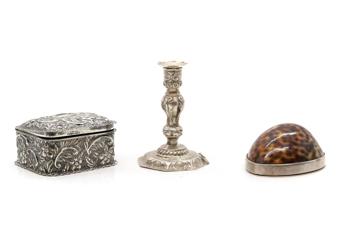A Victorian silver pill box,: A Victorian silver pill box, by Deakin & Francis, Birmingham 1892, with stylised repoussé decoration, 7cm wide 6cm deep 4cm high, together with a small silver candlestick, possibly by John Tongue