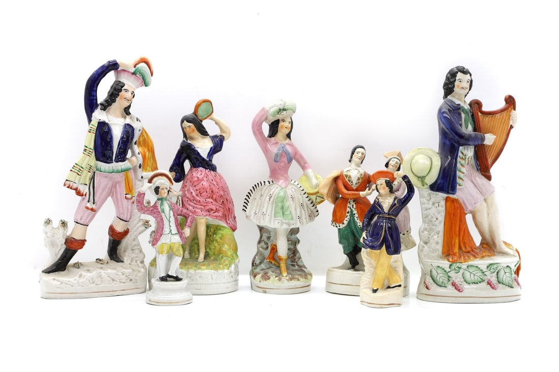 A collection of seven Staffordshire pottery figures,: A collection of seven Staffordshire pottery figures, mid-19th century, modelled as dancers and a man playing the harp, 32cm to 17cm high (7) Condition Report: Rubbing and gilt wear.