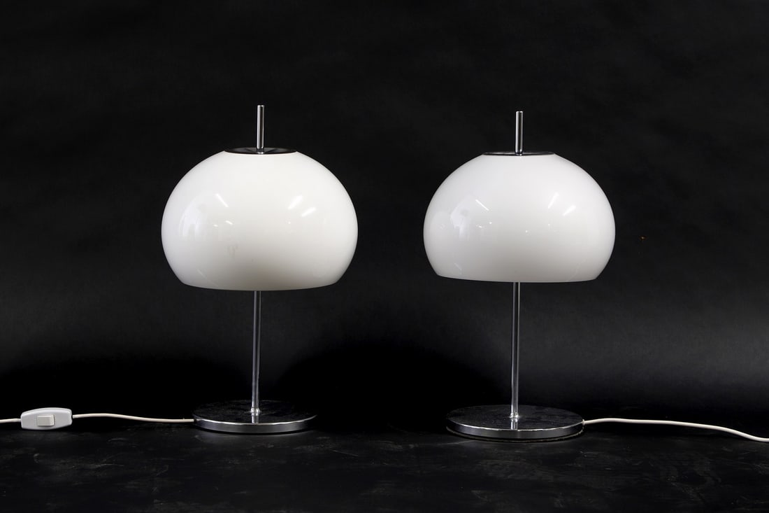 A pair of Harvey Guzzini syle table lamps,: A pair of Harvey Guzzini syle table lamps, 1970s, Italian, with white acrylic domed shade on a chrome column and a circular base, 28cm diameter 52cm high
