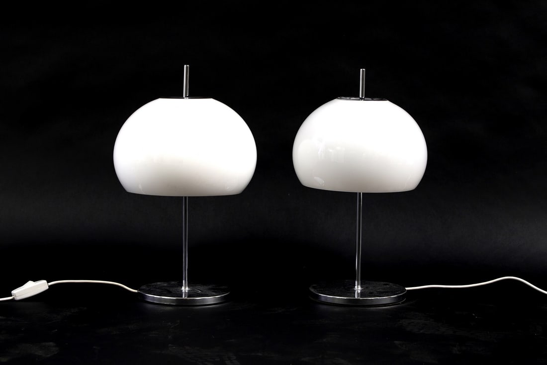 A pair of Harvey Guzzini style lamps,: A pair of Harvey Guzzini style lamps, 1970s, Italian, with white acrylic domed shade on a chrome column and a circular base, 28cm diameter 52cm high