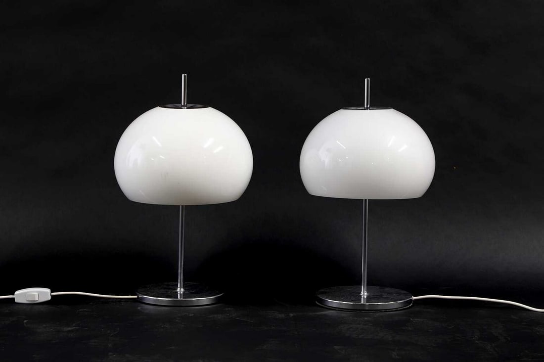 A pair of Harvey Guzzini syle table lamps,: A pair of Harvey Guzzini syle table lamps, 1970s, Italian, with white acrylic domed shade on a chrome column and a circular base, 28cm diameter 52cm high Condition Report: PAT test failed.