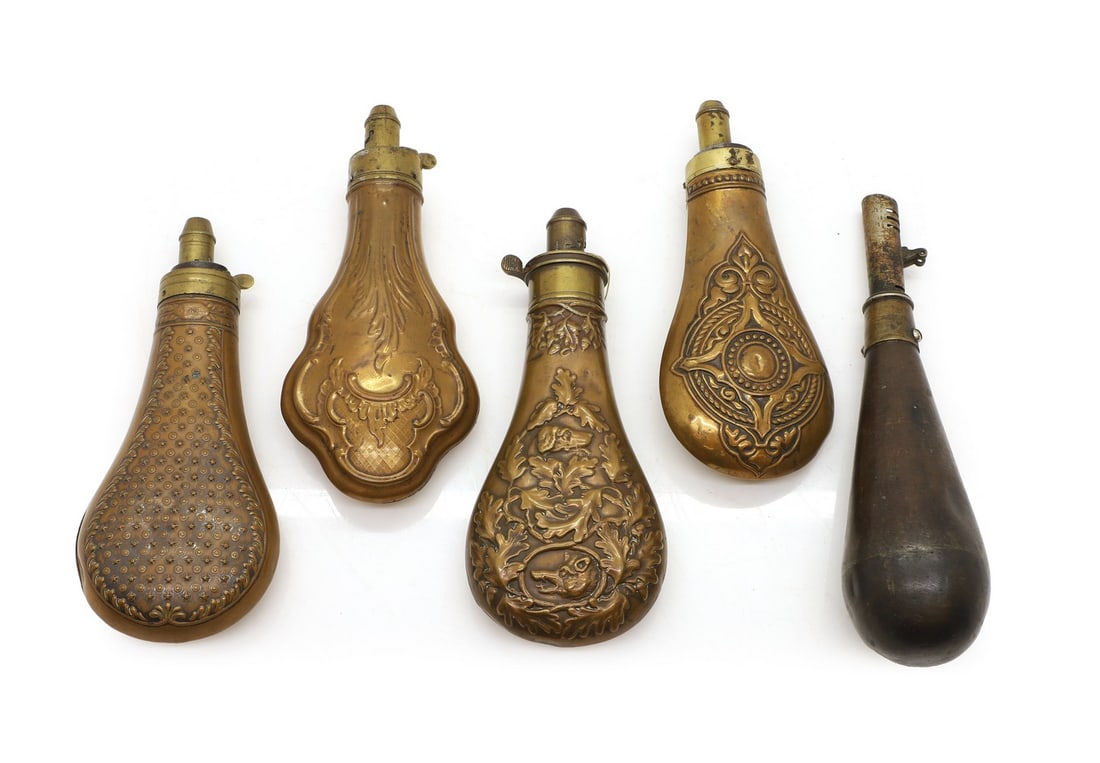 Four Victorian copper and brass shot and powder flasks,: Four Victorian copper and brass shot and powder flasks, each with embossed decoration, the largest 20.5cm; and another, lacking its end, 23cm long (5) Shipping Disclaimer: Buyers must be aware of thei