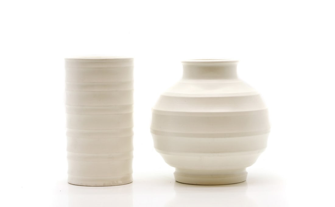 Two Keith Murray pottery vases: Two Keith Murray pottery vases 20th century, for Wedgwood, comprising a globular vase, and a cylindrical vase, both in white, with printed 'Barlaston' marks, 15.5 and 16cm high (2) Condition Report: S
