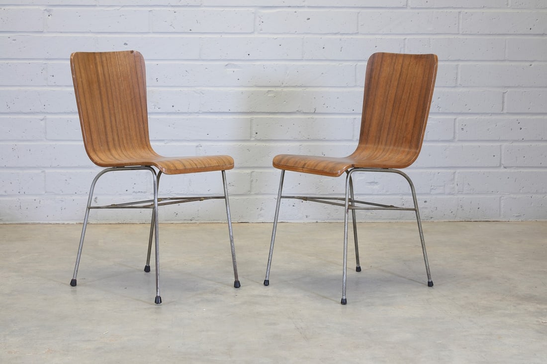 A pair of 'Toby' stacking chairs,: A pair of 'Toby' stacking chairs, designed in 1956 by Neil Morris for Morris of Glasgow, each with a walnut-veneered bent-ply seat, raised on tubular steel supports, impressed with manufacturer's mark