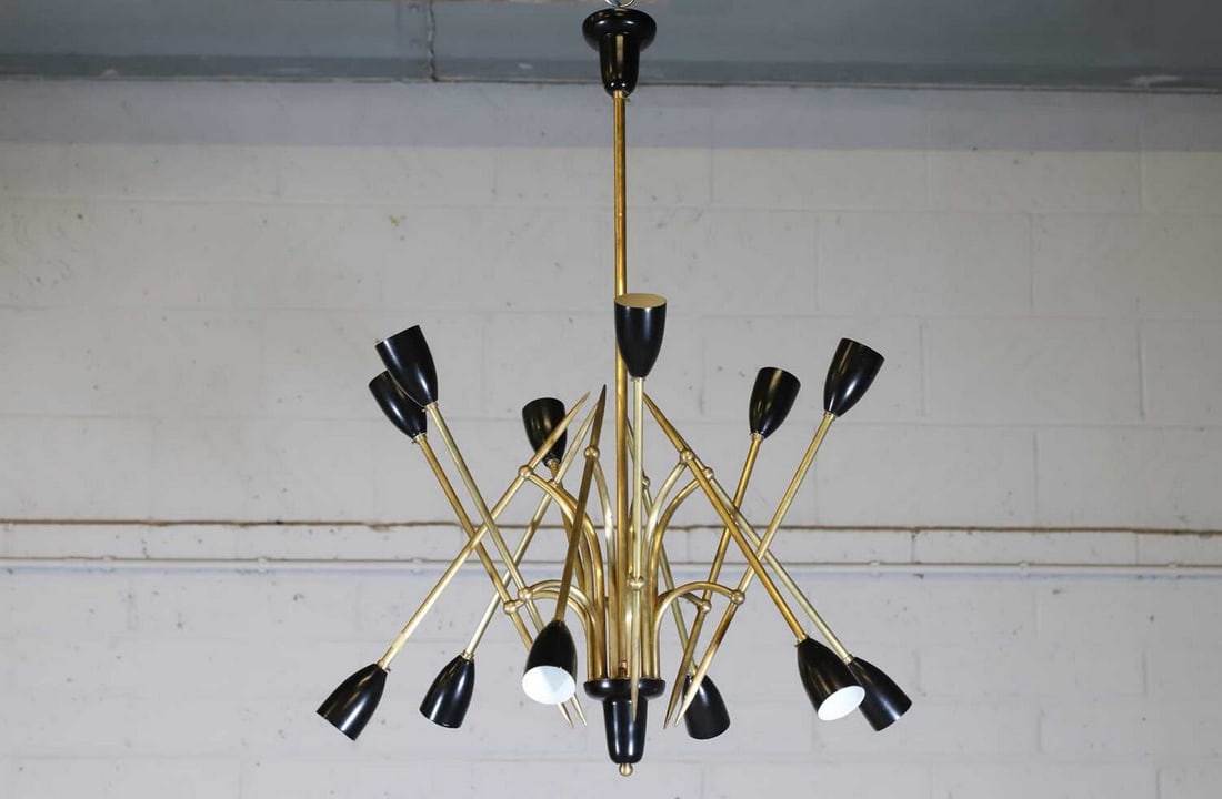 ▲ Attributed to Angelo Brotto (Italian, 1914-2002),: ▲ Attributed to Angelo Brotto (Italian, 1914-2002), a twelve-branch brass ceiling light, c.1960, with black enamel shades and ceiling rose, 56cm diameter 87cm long
