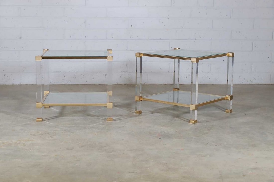 A pair of Pierre Vandel side tables,: A pair of Pierre Vandel side tables, c.1970, each of square form with a glass top and shelf, within a Lucite and gilded-brass frame, complete with paperwork numbered '50385' and '50386' respectively,
