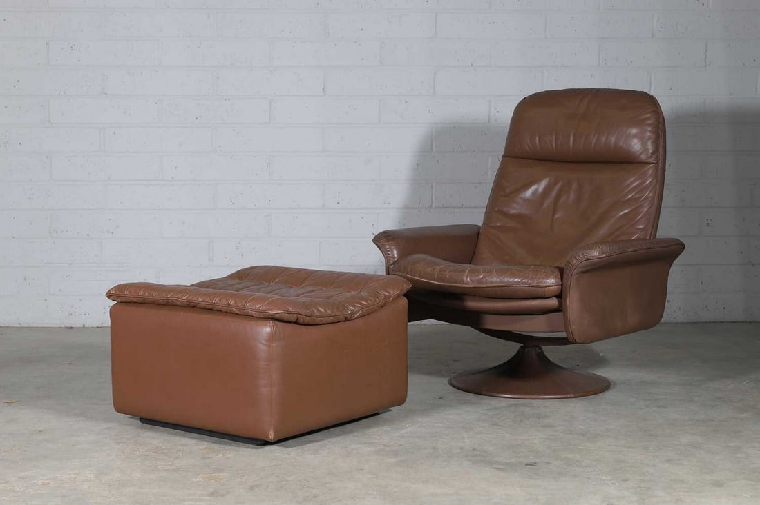 A Swiss De Sede 'DS50' swivel armchair,: A Swiss De Sede 'DS50' swivel armchair, 1970s, the angular stitched panel back, above a cushioned seat, on a circular swivel base, 84cm wide 27cm deep 96cm high, seat 41cm high, together with a matchi