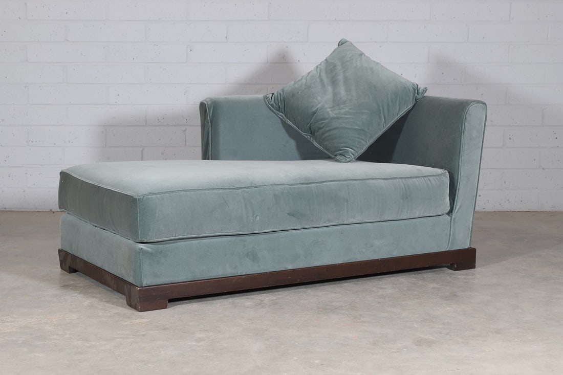 A left-hand facing chaise longue,: A left-hand facing chaise longue, of recent manufacture, the green velvet upholstered seat supported on a dark teak wood frame and block feet, with matching cushion, 160cm long 90cm deep 70cm high, se