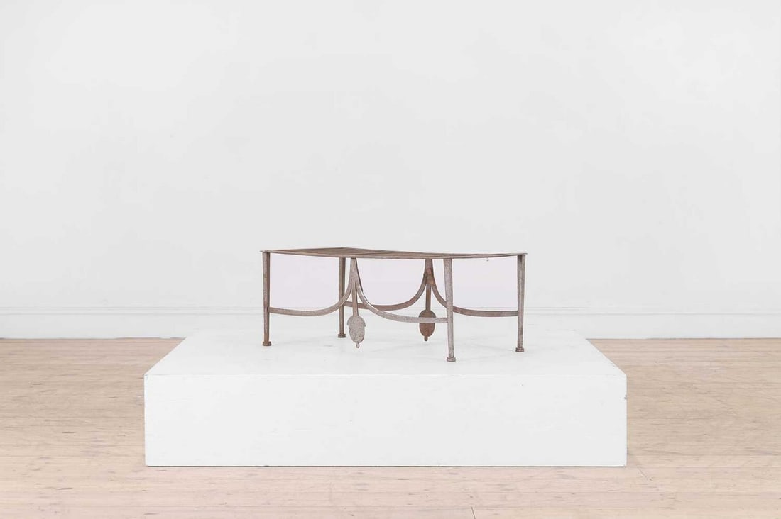 A George III steel trivet,: A George III steel trivet, c.1790, a rectangular grille top, raised on tapering square supports, united by sweeping stretchers with acorn terminals, 61cm wide 33cm deep 24cm high Provenance: The colle