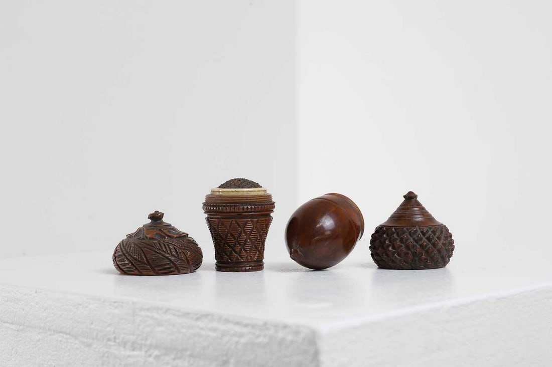 Two coquilla nut nutmeg graters,: Two coquilla nut nutmeg graters, 19th century, comprising: one carved as an acorn, 8cm high, and another, carved as a basket with bone-mounted metal grater, 6cm high (2) Condition Report: Both graters